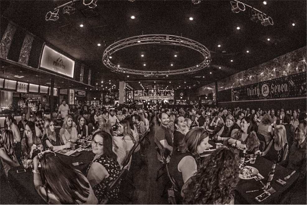 Packed crowd at a comedy venue, black and white